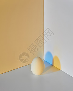 种彩色灰鸡蛋,带的双层黄灰色背景周围反射蓝阴影复活节灰双背景上画鸡蛋,反射蓝色黄色图片