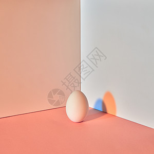 种多色的鸡蛋,灰褐色的双背景上,反射蓝色橙色的阴影,并为文本复活节布局彩色鸡蛋与蓝色橙色阴影的反射周围的双米图片