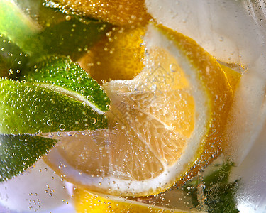 片柠檬石灰,杯子里气泡的水清爽柠檬水的观照片新鲜石灰柠檬片的观照片,璃中气泡夏天的冷饮图片