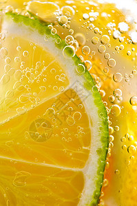 黄色柠檬片石灰的观照片,装水的璃中很多气泡夏季清爽鸡尾酒多汁的成熟柠檬片石灰,杯水中气泡清爽柠檬图片