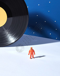 太空人的塑料玩具,蓝天背景下的光表,星星黑色乙烯基记录为个行星,硬阴影,文字的地方外层外层宇航员黑色乙图片