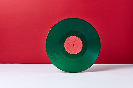 种圆形音乐,绿色乙烯基唱片,背景为双色红色灰色复古音频技术文本的位置老式绿色乙烯基记录磁盘上的双调背景图片
