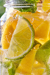 切开的柠檬片璃瓶与冷清爽的排水与石灰,柠檬片薄荷与气泡的空气冷却饮料背景冷清水与石灰柠檬璃背景