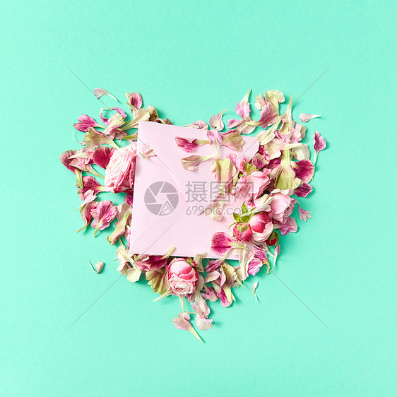 祝贺卡与花心玫瑰工艺信封上的浅绿色背景,地点为文字顶部视图玫瑰花心与信封的邮政卡个浅绿色背景图片