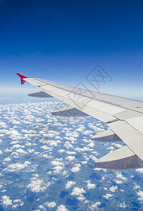 飞行云层之上的飞机的机翼图片