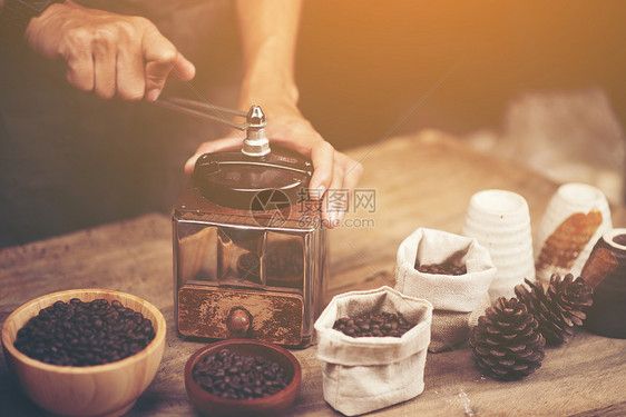 木制背景上的老式咖啡磨床豆子图片