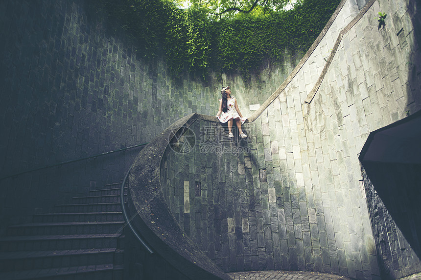 轻的女孩旅行者坐圆形楼梯的螺旋楼梯的地下通道坎宁堡公园,新加坡图片