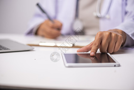 医生纸上手工书写处方医生写白色白纸上的手的顶视图,药品木桌上的胶囊健康医疗理念图片