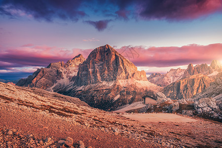 意大利白云石日落时的山脉风景与高岩石,石径,小房子,蓝天与粉红色的云彩晚上秋天的风景与山谷意大利阿尔卑斯山黄昏图片