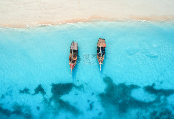 夏天的日落时,清澈的蓝色水中俯瞰渔船无人驾驶的船,沙滩上俯瞰印度洋非洲桑给巴尔旅行景观与帆船,海洋海图片