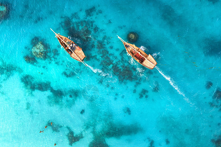 夏天的日落时,清澈的蓝色水中俯瞰渔船无人驾驶的船,沙滩上俯瞰印度洋非洲桑给巴尔旅行景观与帆船,海洋海图片