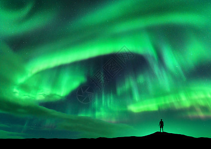 北极光站立的人的轮廓挪威洛福腾群岛极光快乐的人天空中星星绿色的北极光夜间景观与极光人旅行背图片