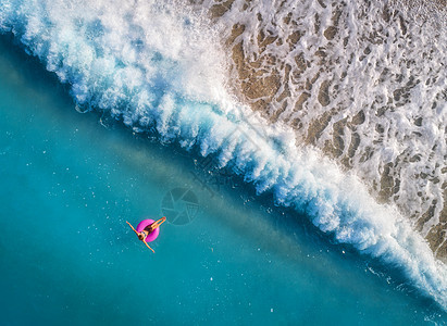 鸟瞰轻女子游泳粉红色的游泳环透明的绿松石海,土耳其奥卢德尼斯夏天的海景与女孩,美丽的波浪,蔚蓝的水阳光明媚的日子图片