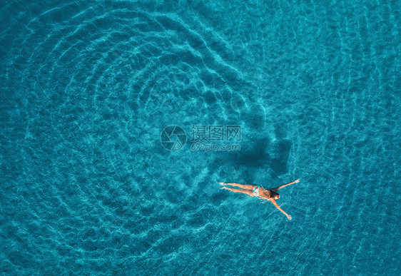 蓝色泻湖游泳女子的鸟瞰图土耳其奥卢德尼茨的地中海夏天的海景与女孩,清澈的蔚蓝的水,波浪阳光明媚的日子透明的水飞图片