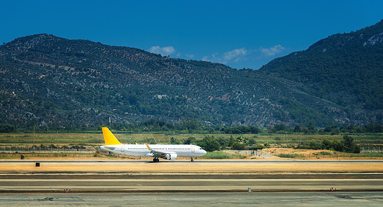 德拉曼机场跑道上美丽的白色飞机风景与大客机正飞山脉明亮的阳光明媚的日子夏天出差商用飞机旅行德拉曼机图片