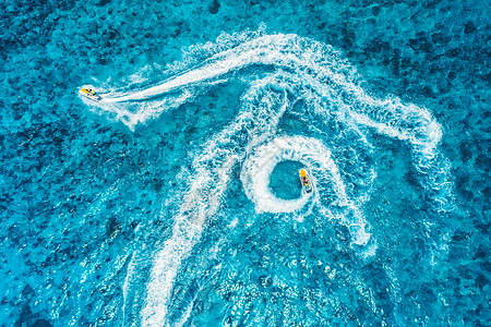 夏季日落时蓝色水中浮水滑板车的鸟瞰图印度洋,桑给巴尔,非洲度假喷气滑雪运动的顶部视图热带海景与移动摩托艇极端图片