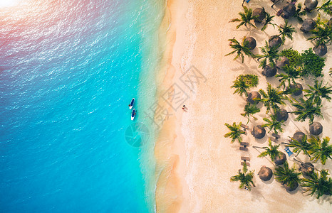 日落时,遮阳伞沙滩上的棕榈树海上的皮艇的鸟瞰图非洲桑给巴尔的暑假热带景观棕榈树,阳伞,船,沙子,碧水的风景图片