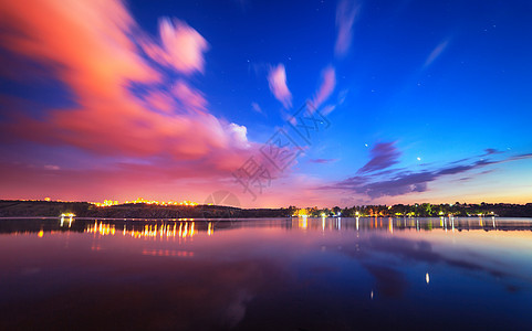 湖上五颜六色的夜景,蓝天移动的云映水中自然背景图片