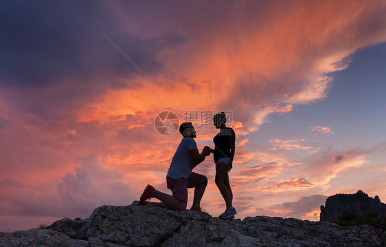 风景与个男人的剪影,向他的女朋友求婚,山峰上五颜六色的日落情人的剪影夫妇人,关系图片