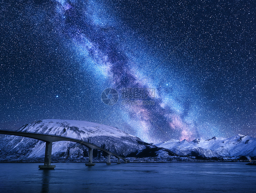 桥星空与银河雪覆盖的山脉反射水中夜间景观与道路,雪岩,紫色的天空与星星银河,海洋挪威洛福滕岛的冬天图片