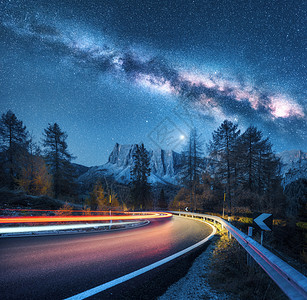 银河山路上秋天蜿蜒的道路上模糊的汽车前灯五颜六色的夜景,蓝色的星空,银河,月光,光小径,岩石,树木公路图片