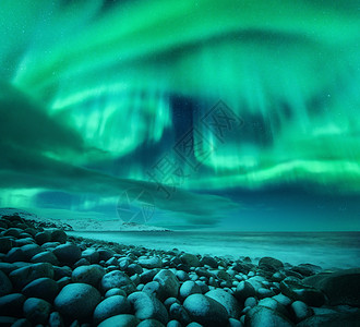 北极光海洋上俄罗斯泰伯卡的北极光星空与极地的灯光云彩夜间冬季景观与美丽的极光,海洋与冻结的石头模糊的水旅行图片