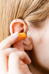 女人把耳塞塞进耳朵里,响亮的地方消除噪音女人把耳塞图片
