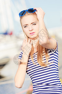 夏天人的时尚可爱的金发女孩,心形太阳镜码头与游艇港口图片