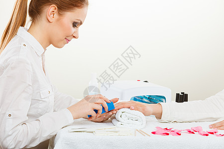 职业工作美丽健康的轻的职业女美容师给她的女客户指甲美甲师专注于完美的结果女美容师指甲图片