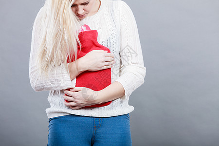 疼痛期月经痉挛问题的胃抽筋的女人抱着热水瓶感觉很舒服女人抱着热水瓶感觉胃抽筋图片