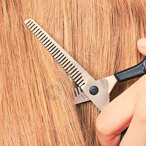 专业的切割理发店特写细节设备黑色特殊剪刀剪金色直长光滑的头发特写细节特殊剪刀剪头发图片