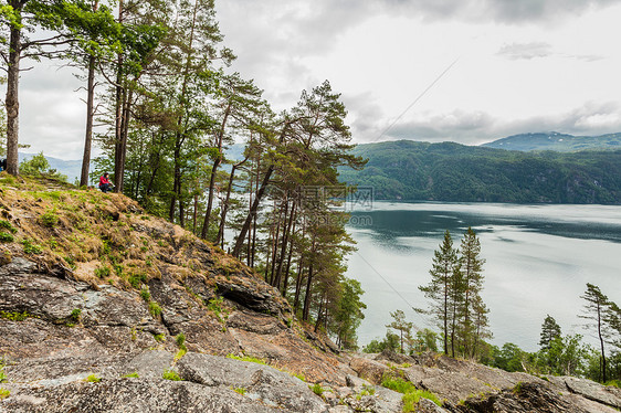 阴天欣赏峡湾风景的女游客,斯万达尔斯福森瀑布地区观看挪威景观旅游Ryfylke路线女游客挪威享受峡湾景观图片