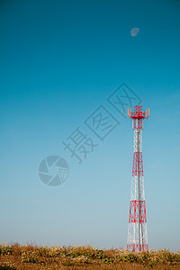 白色红色信号塔映衬着晴朗的蓝天工业自然比信号塔抗蓝天背景图片