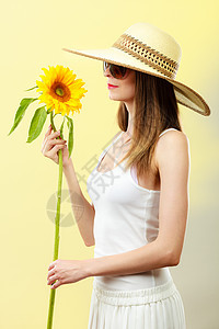 迷人的夏天女人戴着太阳镜,草帽,手里着黄色背景的向日葵图片