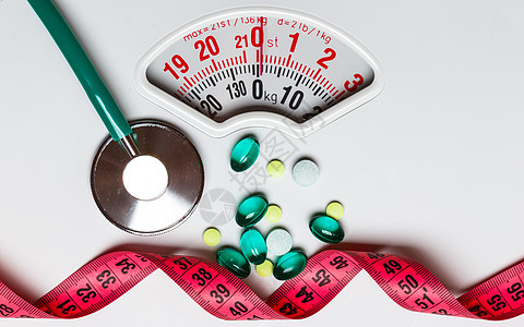 健康饮食医药保健食品补充剂减肥理念带测量带听诊器的药丸白色鳞片上图片