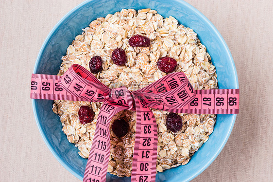 饮食健康食品减肥理念蓝色碗里的燕麦片,厨房桌子上测量胶带图片
