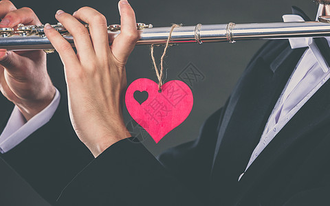情人节爱情旋律长笛音乐演奏男子流感音乐家表演者男手用乐器红心,特写长笛心脏的男流感医生爱的旋律图片
