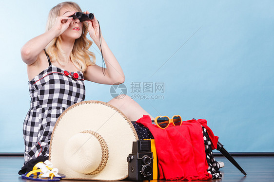 旅行包装,旅行女人透过望远镜看着,坐地板上,着手提箱,装满了准备暑假的东西轻的女人收拾手提箱图片