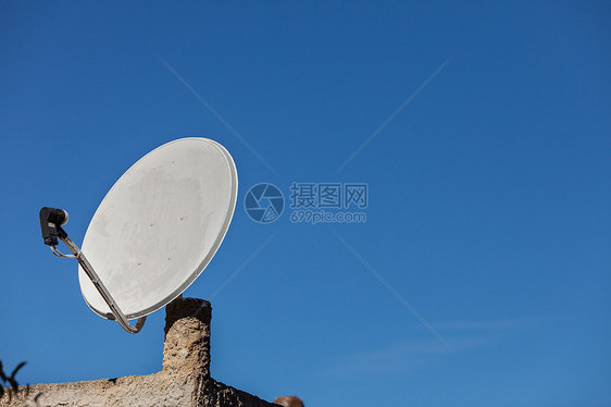 白色卫星碟,背景蓝天家庭屋顶上的电视天线无线技术数字设备蓝天上的卫星天线图片