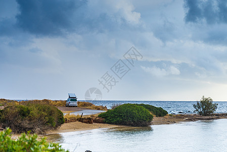 露营拖车汽车海边多云的夏季天气里,汽车海边的海滩上海边的野营卡车图片