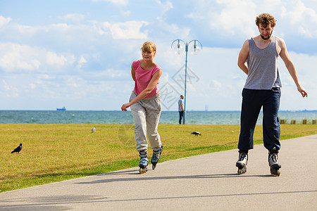 爱浪漫休闲户外健身运动理念轻的骑着溜冰鞋公园女孩男孩穿着溜冰鞋轻的公园骑着旱冰车背景图片