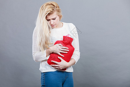疼痛期月经痉挛问题的胃抽筋的女人抱着热水瓶感觉很舒服女人抱着热水瓶感觉胃抽筋图片