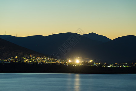 阿斯特罗斯镇的夜景与风力涡轮机山上,希腊佩罗蓬尼斯可再生生态能源夜间的天体城希腊,山上的风力涡轮机图片