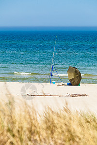 钓鱼竿帐篷独自留海边阳光明媚的夏季天气海边的钓鱼竿帐篷图片