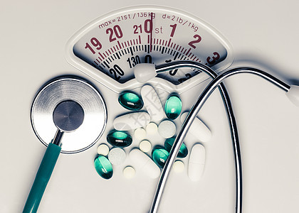 健康饮食医药保健食品补充剂减肥理念白色鳞片上听诊器的药丸图片