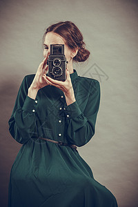 女人复古风格的深色长袍与旧相机拍照,复古照片图片