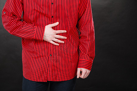 健康问题,关节紧张的穿红衬衫的男人的特写患胃痛穿红衬衫的人胃痛图片