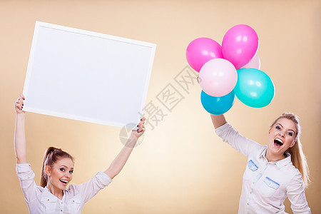 广告,节日庆祝微笑快乐的女孩着展示板,横幅五颜六色的气球,玩得开心两个女孩着空白板气球图片