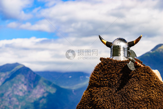 挪威峡湾岸边戴着头盔斧头的维京战士旅游旅游挪威峡湾海岸的维京战士图片