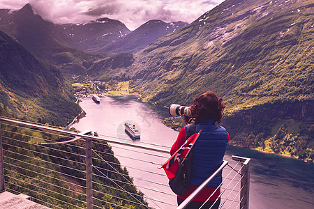 旅游假日图片旅游奥恩斯文根鹰路角度欣赏峡湾景观的女游客,用相机拍照,挪威游客拍摄峡湾景观,挪威图片